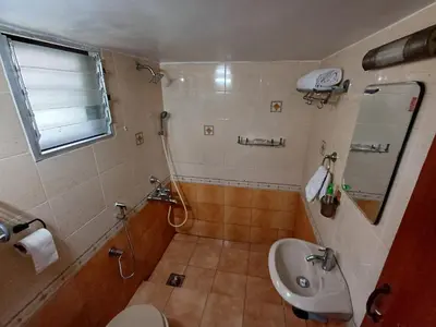 a bathroom with a sink and a toilet and a mirror at Unwind @ Serene Retreat in Palakkad