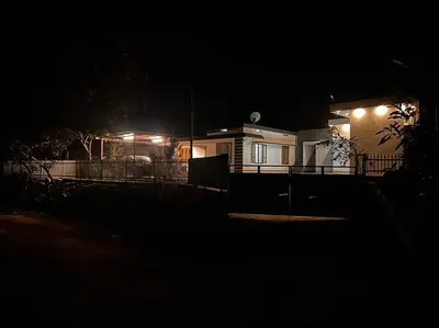 a house at night with lights in front of it at Nila Farms - Farm stay with a unique swimming Pool in Attappādi