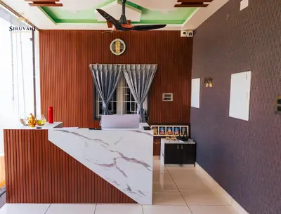 a kitchen with a counter and a clock on the wall at Siruvani Residency - Near Isha Foundation Coimbatore in Alāndurai
