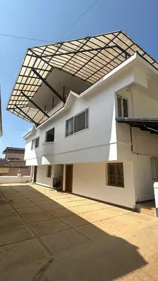 a large white building with a large roof at Amarah Homestay in Ooty