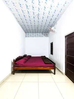 a bedroom with a bed in a room with a ceiling at Winter Villa Karapuzha in Wayanad