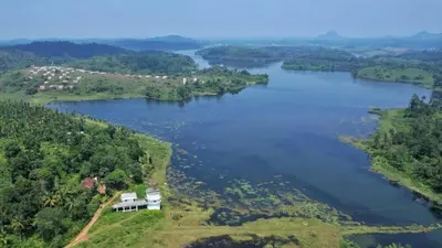 an aerial view of a lake with a house at Winter Villa Karapuzha in Wayanad