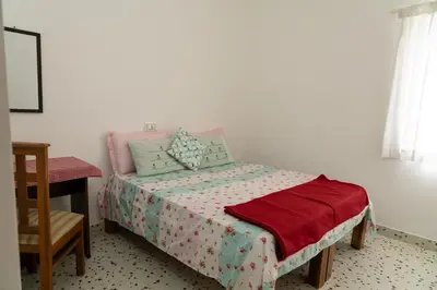 a bedroom with a bed with a table and a chair at Maya Homez - Coimbatore in Coimbatore