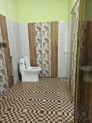 a bathroom with a toilet and a tiled floor at Pavithra cottage munnar in Munnar