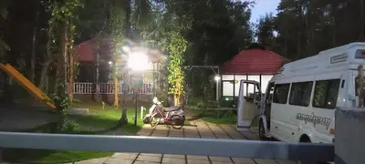 a motorcycle parked in a yard next to a bus at Le Vista Resort in Sultan Bathery