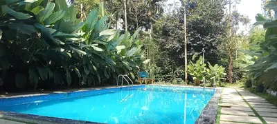 a swimming pool in the middle of a garden at Le Vista Resort in Sultan Bathery