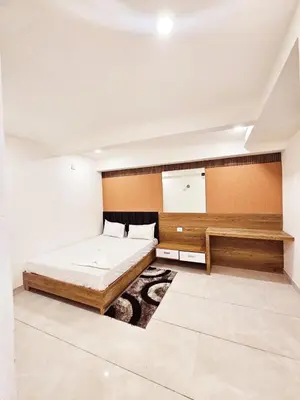 a bedroom with a large bed and a desk at LOWFARE HOTELS in Kozhikode