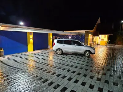 a white car parked in a parking lot at night at Coastal Grand Resorts - Akshaya in Kotagiri