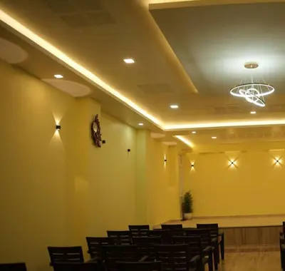 a room with a bunch of chairs and a ceiling at Coastal Grand Resorts - Akshaya in Kotagiri