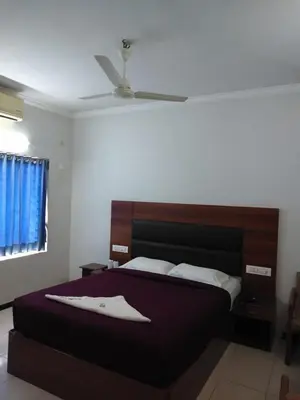 a bedroom with a bed and a ceiling fan at Asoka Inn in Mettuppālaiyam