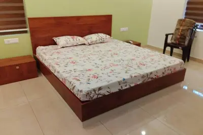 a bedroom with a bed with a wooden headboard at Home stay - Near Cochin Airport in Angamali