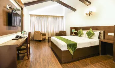 a hotel room with a bed and a desk at Treebo Skydale Inn & Suites With Mountain View in Ooty