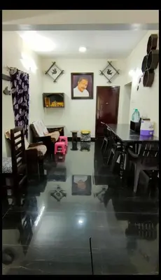 a living room with a table and a couch at Arulmozhi Dream in Ooty