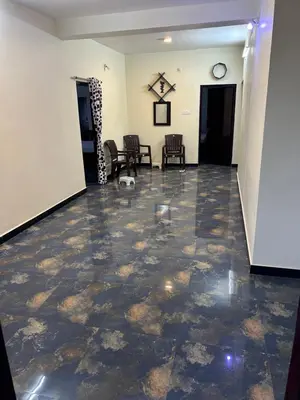 an empty lobby with a tile floor and chairs at Arulmozhi Dream in Ooty