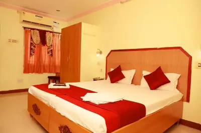 a bedroom with a large bed with red and white pillows at KG Grand Inn in Erode