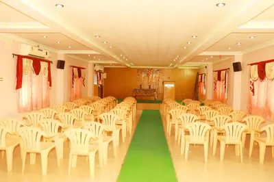 an empty room with white chairs and a green floor at KG Grand Inn in Erode