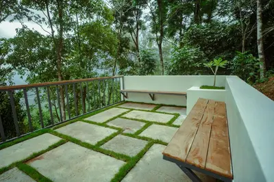 a wooden bench sitting on top of a balcony at Nila Paithal in Paithalmala