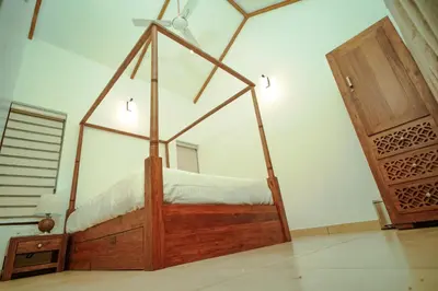 a bedroom with a wooden bed and a mirror at Nila Paithal in Paithalmala