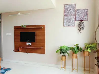 a living room with a tv on a wall at 2BHK Flat by SR Renton Comfort Homestay Mysore @ Vijayanagar 2nd stage Mysore in Mysore