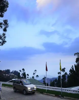 a car parked in a parking lot next to a bridge at Sabol Holidays in Ooty