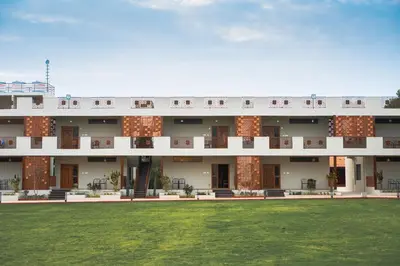 a building with a lawn in front of it at Poojaris Nirantara - Mysuru in Hampāpura
