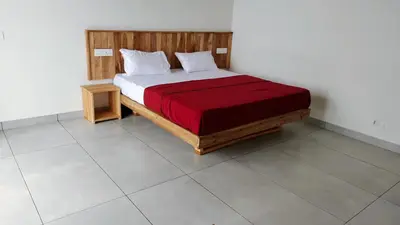 a bedroom with a bed with a red blanket at Mist View Resort Wayanad in Wayanad