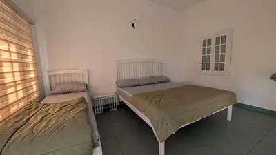two beds in a room with a window at Meghamalhar in Mānantoddy