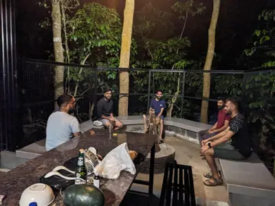 a group of people sitting around a table at Meghamalhar in Mānantoddy