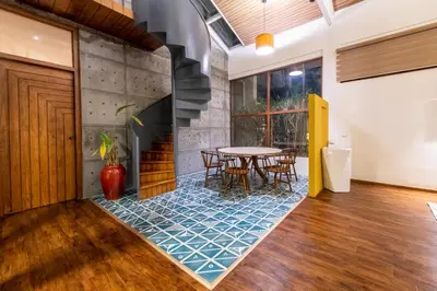 a dining room with a table and chairs on a tile floor at Asta in Ooty
