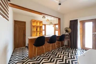 a room with a bar with chairs and a window at Asta in Ooty