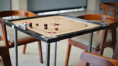 a ping pong table with four chairs around it at M!steria Inn in Wayanad