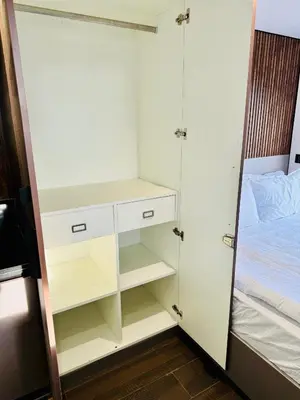 a closet with a white cabinet next to a bed at The Jade Highlands Mountain View Cozy container 2bhk villa in Kodaikānāl