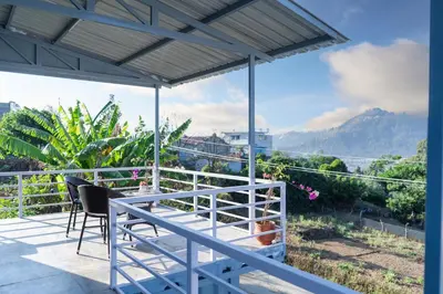 a balcony with chairs and a view of the mountains at The Jade Highlands Mountain View Cozy container 2bhk villa in Kodaikānāl