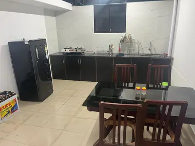 a kitchen with a table and chairs and a refrigerator at THEStay in Alwaye
