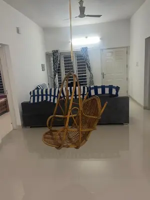 a living room with a rattan chair and a couch at THEStay in Alwaye