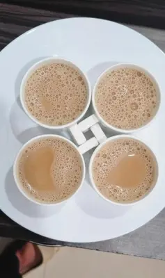 four cups of coffee on a white plate at Karickanattu Nature Resort in Idukki