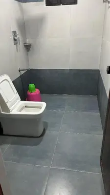 a bathroom with a toilet and a pink container at Kashmir Valley in Kanthalloor