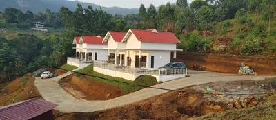 a house with a red roof on a hill at Kashmir Valley in Kanthalloor