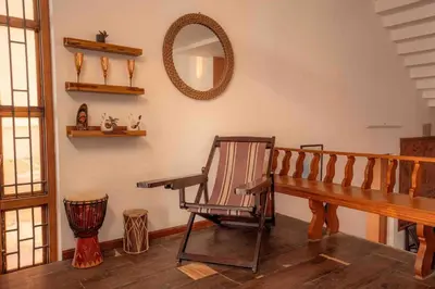 a room with a rocking chair and a mirror at Baywatch by Grha - A Picturesque Beachfront Villa in Kozhikode