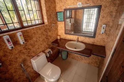 a small bathroom with a toilet and a sink at Baywatch by Grha - A Picturesque Beachfront Villa in Kozhikode
