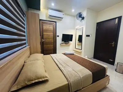 a bedroom with a large bed and a television at NIDRA INN in Kozhikode