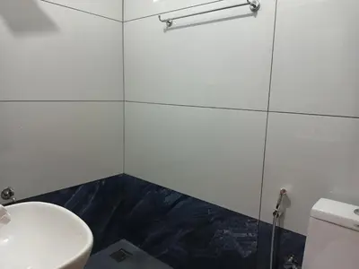 a white bathroom with a sink and a toilet at Eden Homestays in Wayanad