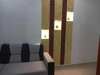 a couch in a room with lights on a wall at Eden Homestays in Wayanad