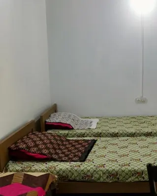 two beds sitting next to each other in a bedroom at Sanctuary View Homestay Thattekad in Ernakulam