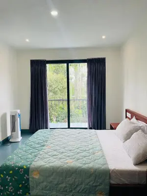 a bedroom with a large bed and a large window at Senthamarai villa in Sultan Bathery