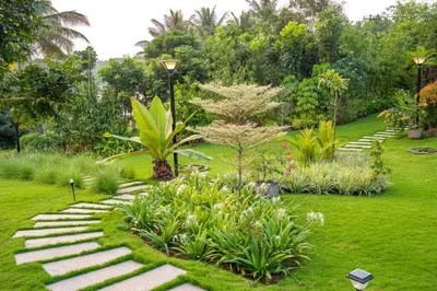 a garden with a stone path in the grass at Villa Woods & Palms in Pollāchi