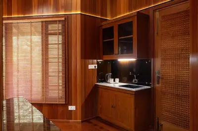 a kitchen with wooden cabinets and a sink at Villa Woods & Palms in Pollāchi