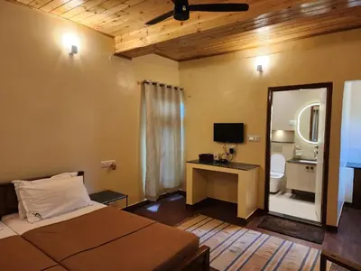 a bedroom with a bed and a mirror and a bathroom at Aranyasun in Masinagudi