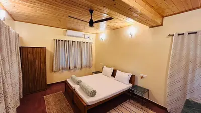a bedroom with a bed and a wooden ceiling at Aranyasun in Masinagudi