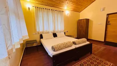 a bedroom with a large bed with a window at Aranyasun in Masinagudi